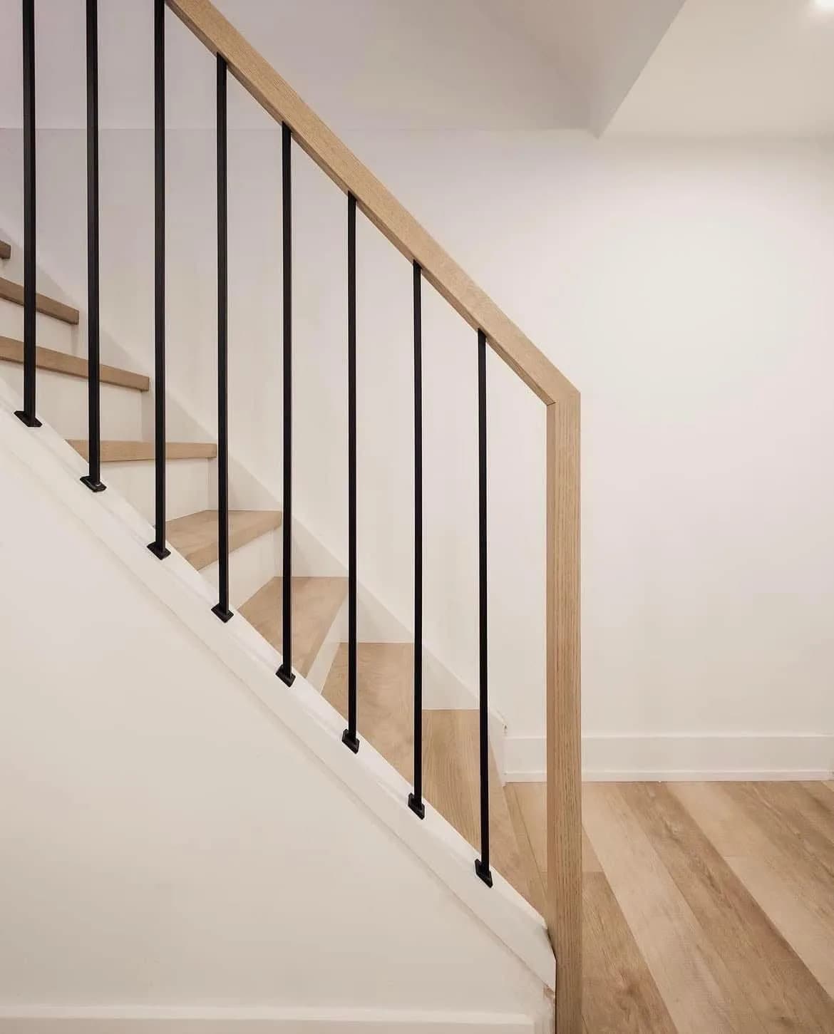 Matte-black slim iron balusters aligned with custom handrail